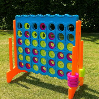 Groot Connect Four spel van kunststof met gekleurde schijven, opgesteld op een grasveld in een tuinomgeving